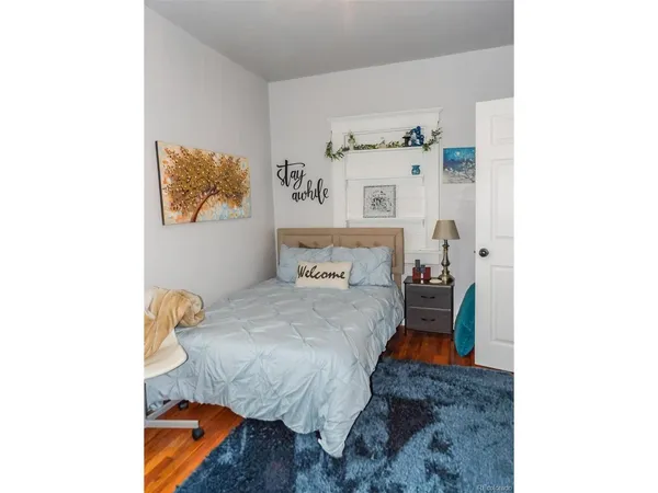 a bed room with a bed and a painting on the wall