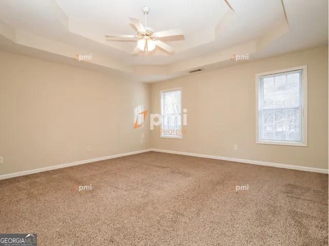 an empty room with windows and fan