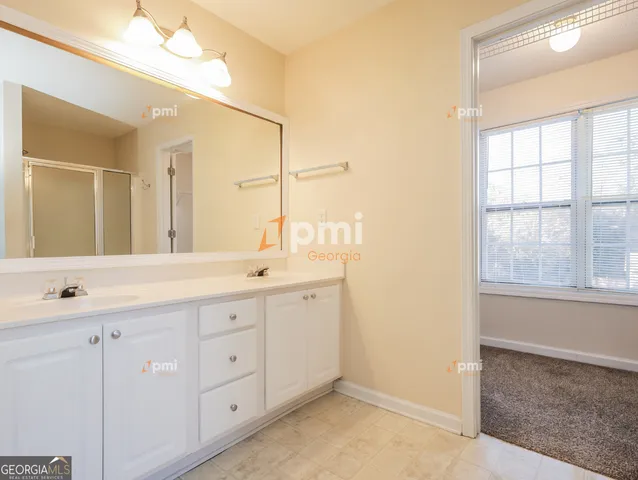 a bathroom with a granite countertop sink mirror and next to a window