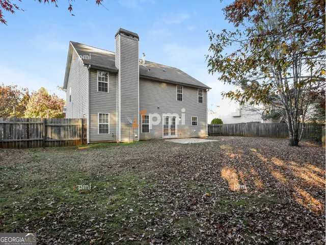 a view of a house with a yard and large tree