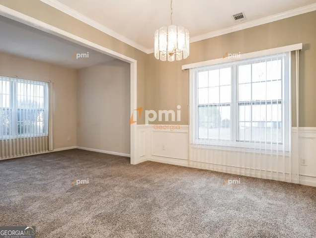 an empty room with chandelier and windows