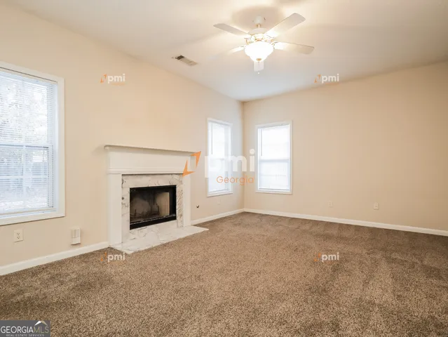 an empty room with windows and fireplace