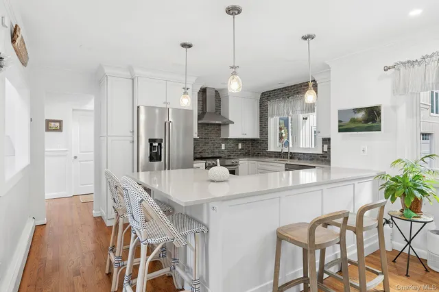 a kitchen with stainless steel appliances a table chairs refrigerator and microwave