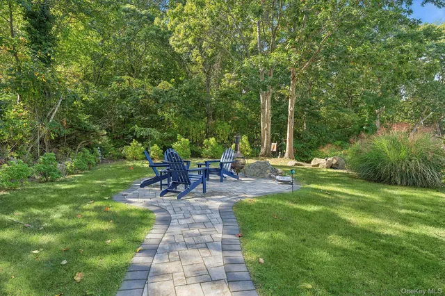 a view of a patio with a table chairs and a small yard