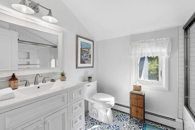 a bathroom with a toilet a sink and mirror