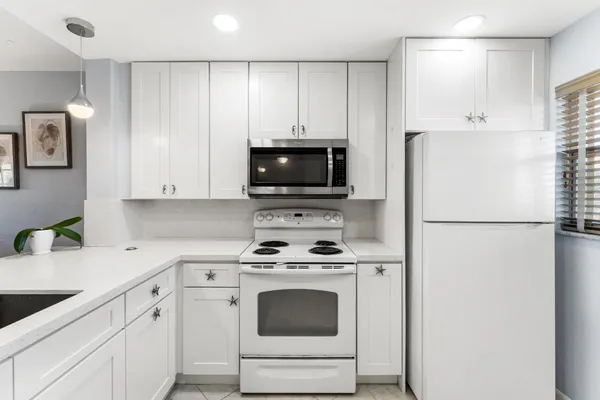 a kitchen with white cabinets and white appliances