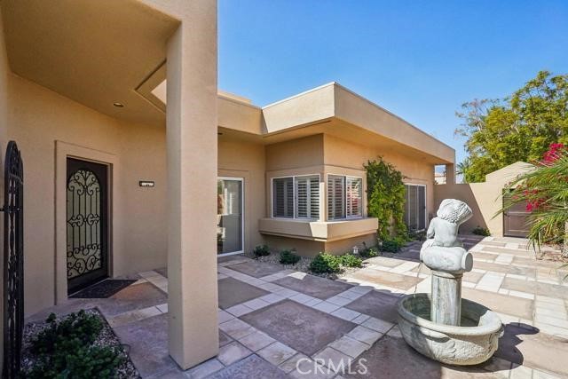 48 Oak Tree Drive Rancho Mirage, CA 92270 - Photo 22 of 31 a front view of a house with a garden