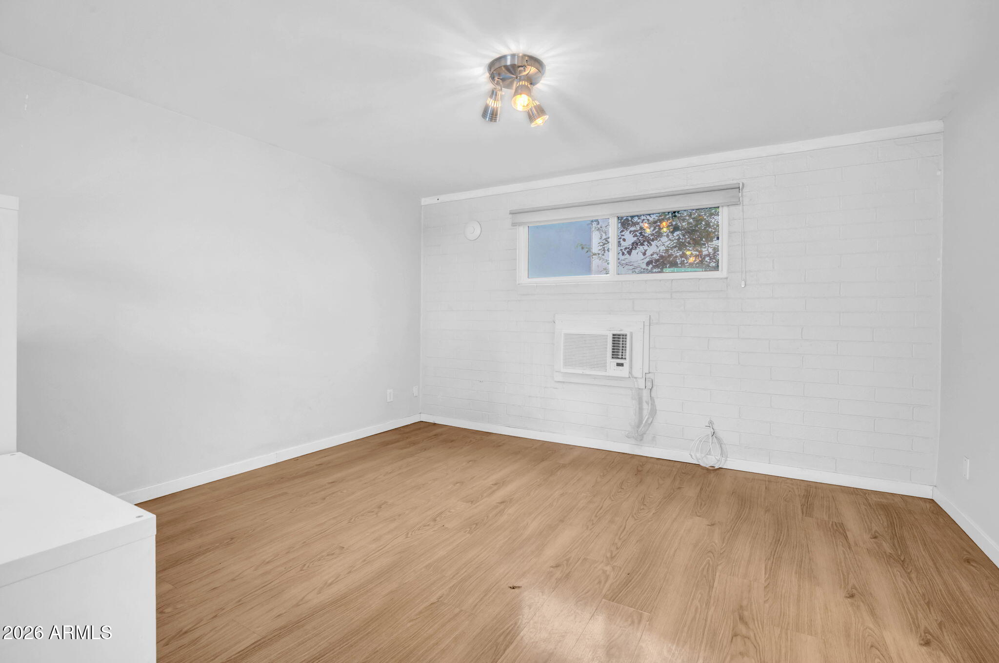 821 North 3rd Street, Unit 3 Phoenix, AZ 85004 - Photo 4 of 10 an empty room with a window and wooden floor