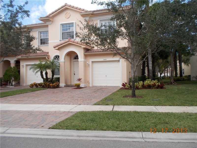 2650 Southwest 84th Terrace, Unit 105 Miramar, FL 33025 - Photo 1 of 12 a view of a white house with a yard and large tree