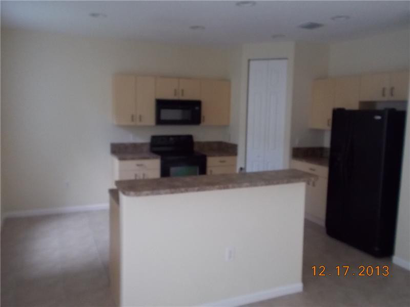 2650 Southwest 84th Terrace, Unit 105 Miramar, FL 33025 - Photo 5 of 12 a kitchen with a refrigerator a microwave a sink and cabinets