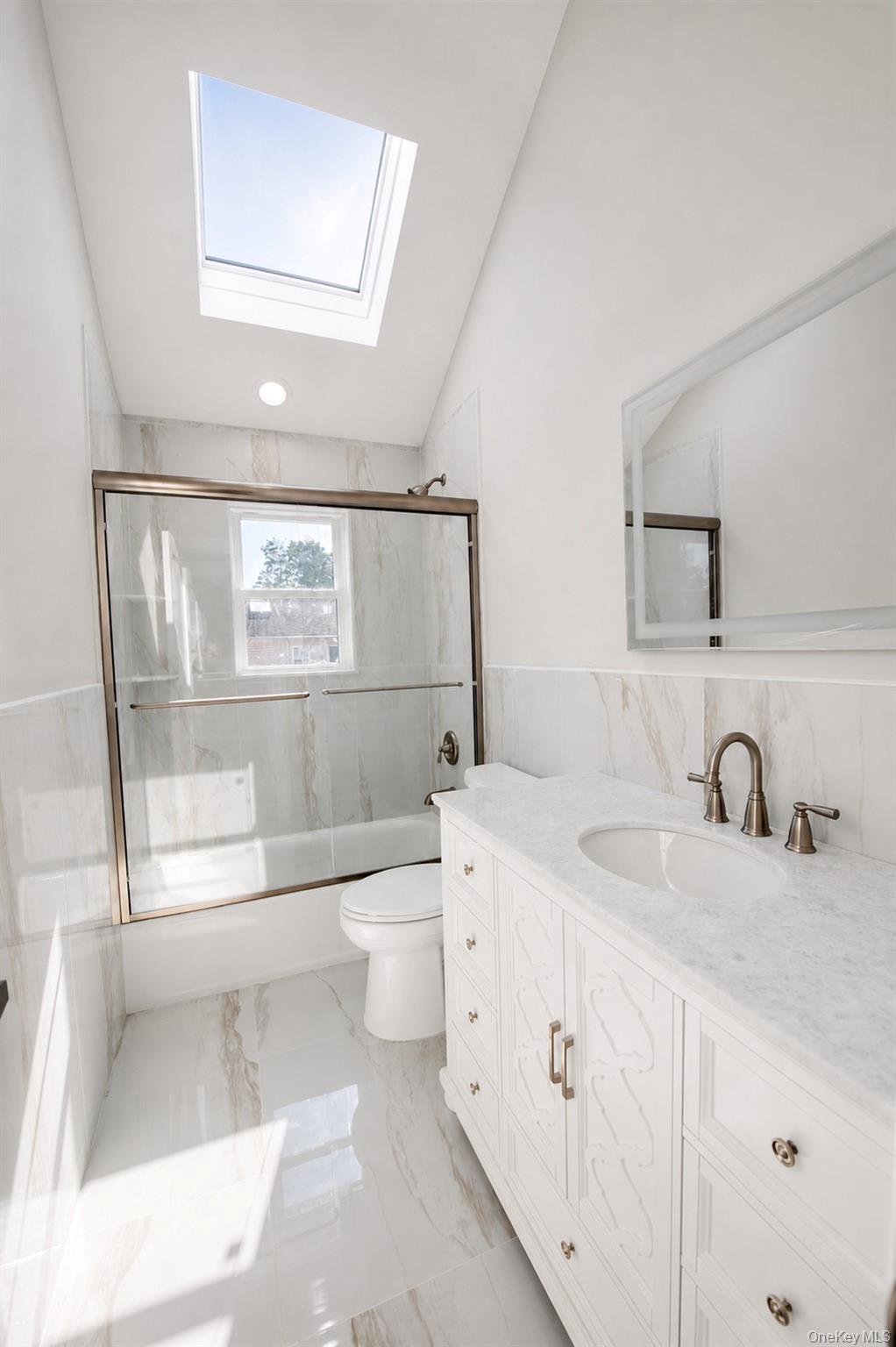 1316 R Street Elmont, NY 11003 - Photo 18 of 24 a bathroom with a sink a toilet and shower
