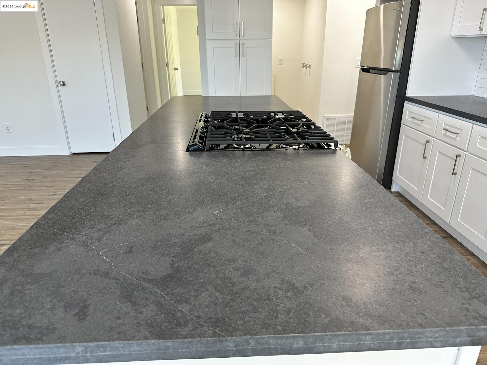 3301 Buchanan Road, Unit 47 Antioch, CA 94509 - Photo 23 of 58 Kitchen featuring dark countertops, wood finished floors, white cabinets, and freestanding refrigerator