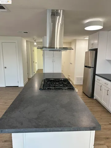 a kitchen with granite countertop stainless steel appliances a sink stove and cabinets
