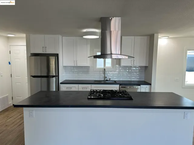 a kitchen with stainless steel appliances a stove a sink and a refrigerator