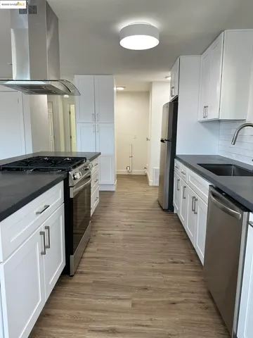 a kitchen with a stove and white cabinets