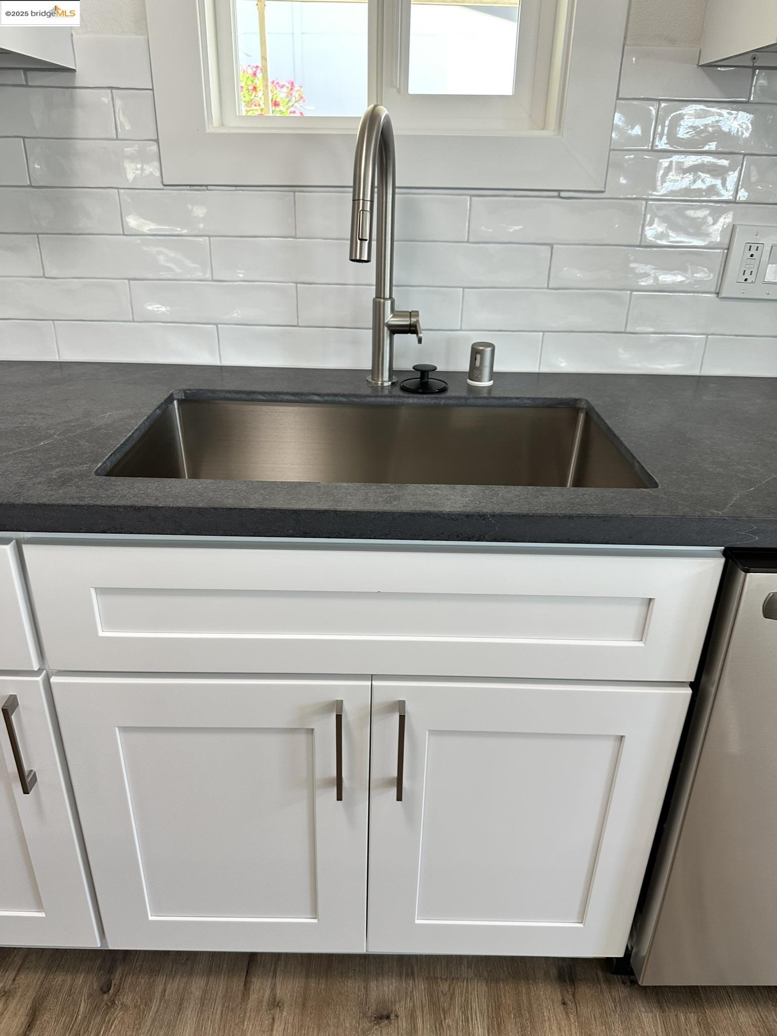 3301 Buchanan Road, Unit 47 Antioch, CA 94509 - Photo 34 of 58 Kitchen view of white cabinetry, dishwashing machine, and decorative backsplash