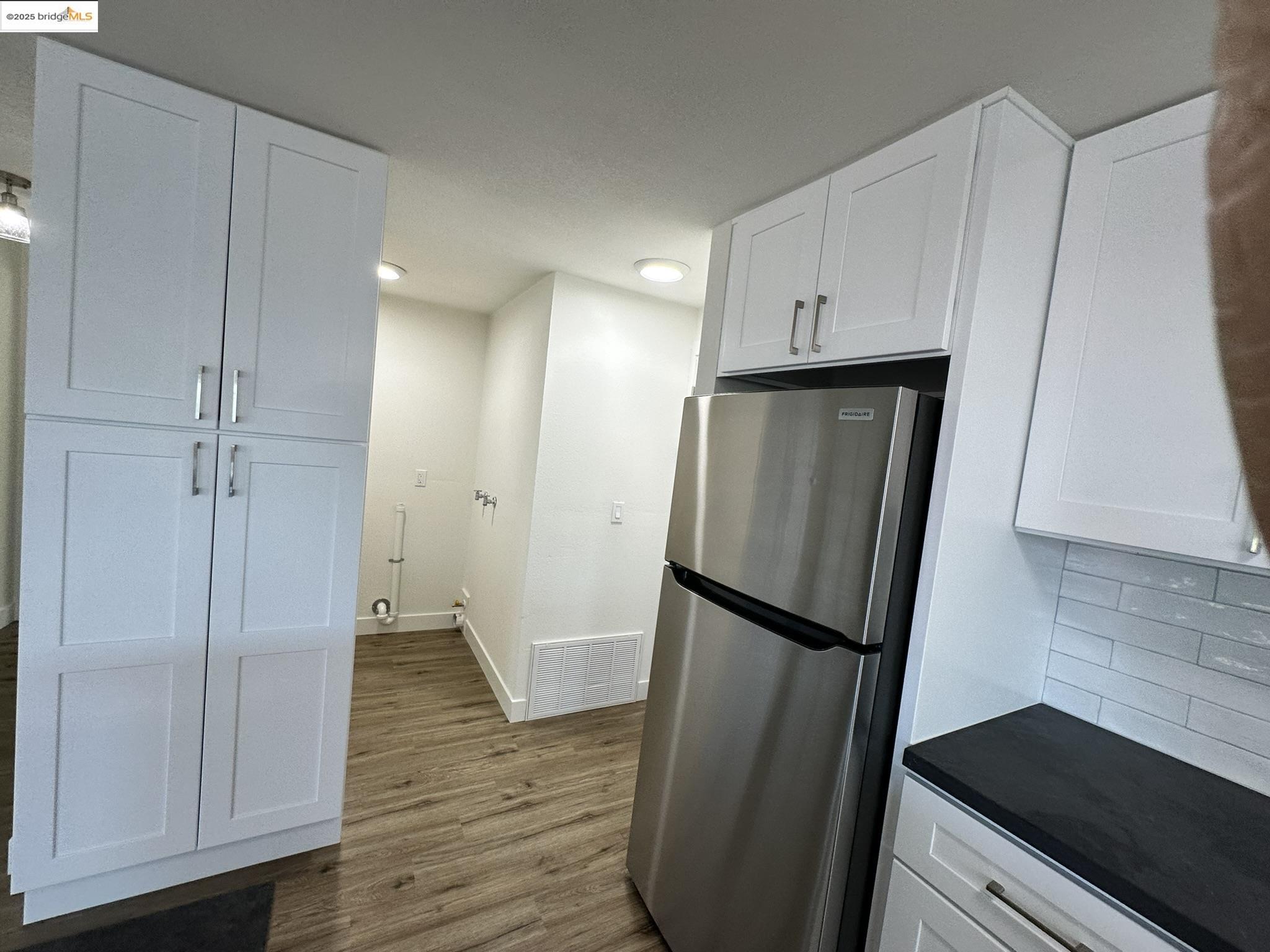 3301 Buchanan Road, Unit 47 Antioch, CA 94509 - Photo 37 of 58 a view of a refrigerator in kitchen and an empty room with wooden floor
