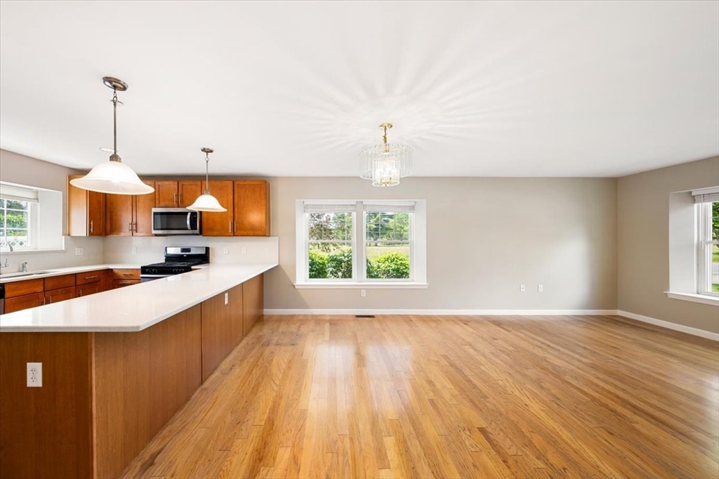 6 Bates Street, Unit A Devens, MA 01434 - Photo 10 of 41 a large kitchen with kitchen island granite countertop a sink a window and stainless steel appliances