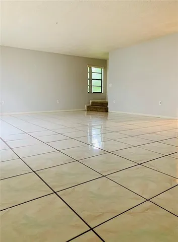 a view of a livingroom with an empty space and a window