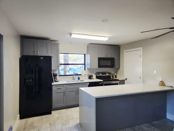 a kitchen with a sink a refrigerator and cabinets