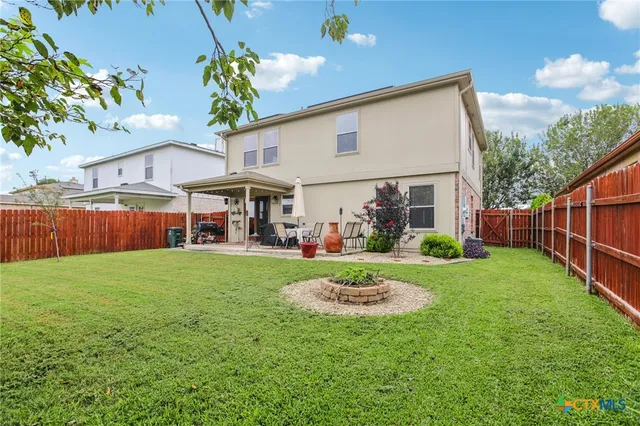 a view of a house with backyard and sitting area
