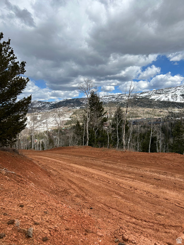 524 West Ski View Drive Brian Head, UT 84719 - Photo 2 of 11 Cleared building site featuring red earth, surrounded by evergreen trees and distant snow-capped mountains