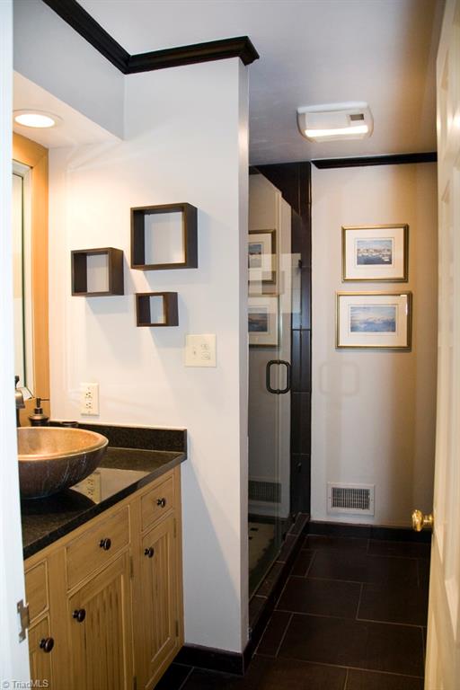 3701 Lewiston Road Greensboro, NC 27410 - Photo 13 of 30 The full bath adjacent to the second main level bedroom. Totally updated with a vessel sink, tile shower and rimless glass door.