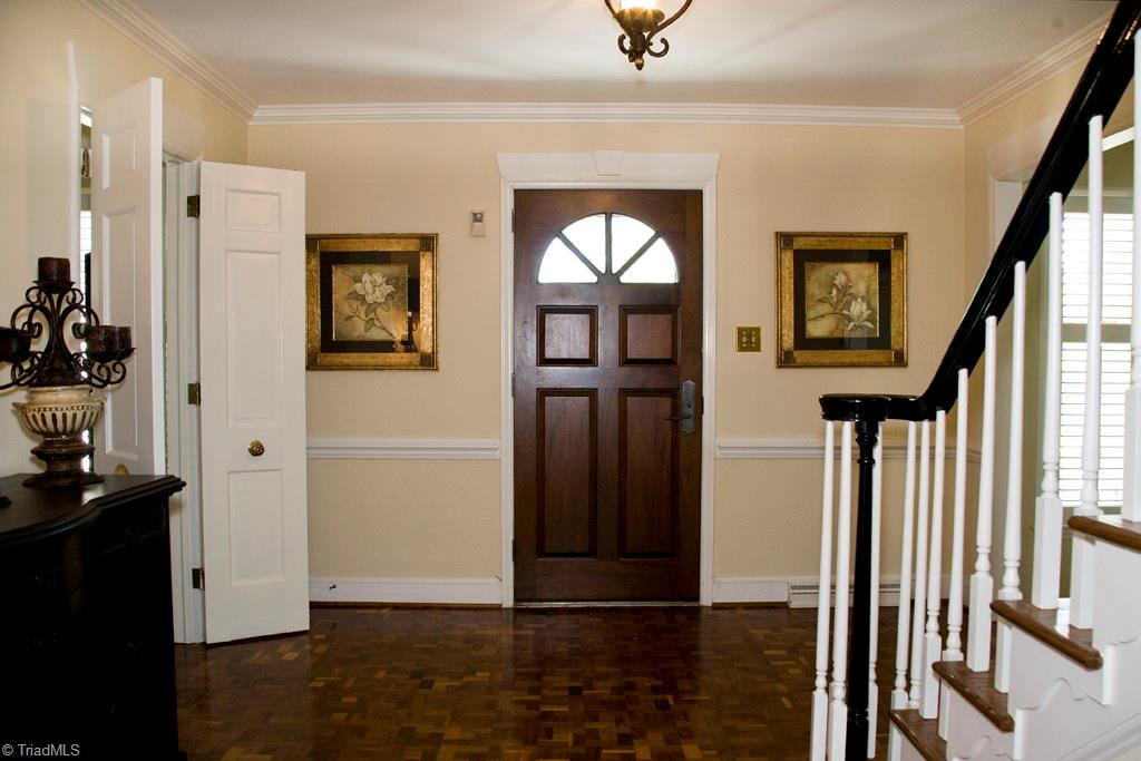 3701 Lewiston Road Greensboro, NC 27410 - Photo 3 of 30 The entry of this super comfortable home is welcoming with an extra wide foyer, chair and crown moldings, parquet wood flooring and flanked with French Doors leading to a Den and Living Room.