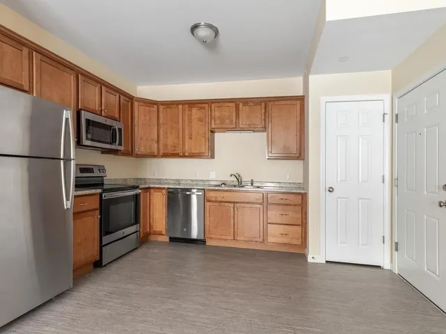 a kitchen with granite countertop white cabinets and stainless steel appliances