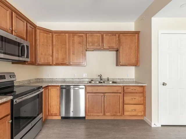 a kitchen with stainless steel appliances granite countertop a stove a sink and a microwave