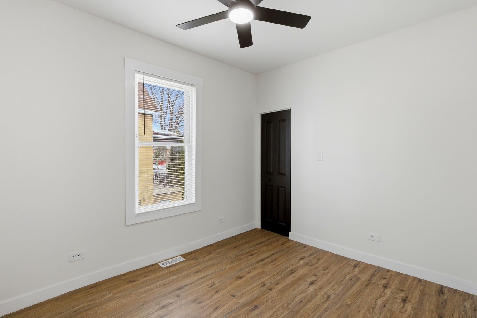 8942 South Aberdeen Street Chicago, IL 60620 - Photo 16 of 35 an empty room with wooden floor ceiling fan and windows