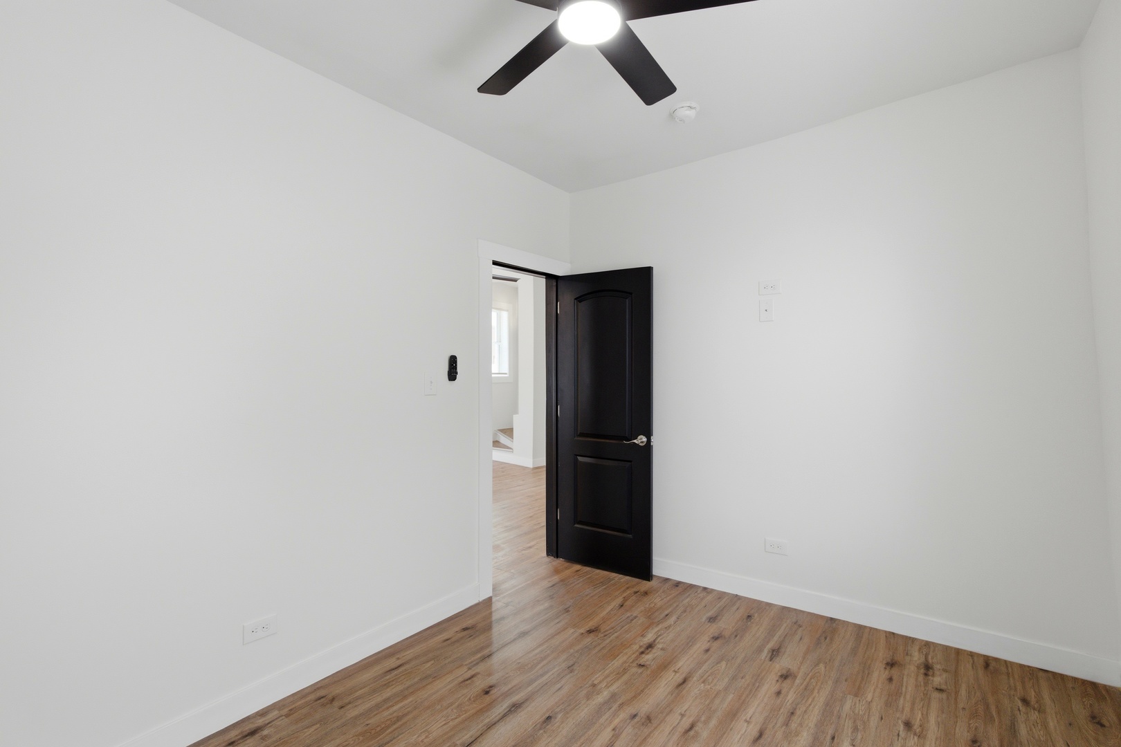 8942 South Aberdeen Street Chicago, IL 60620 - Photo 17 of 35 an empty room with wooden floor and ceiling fan