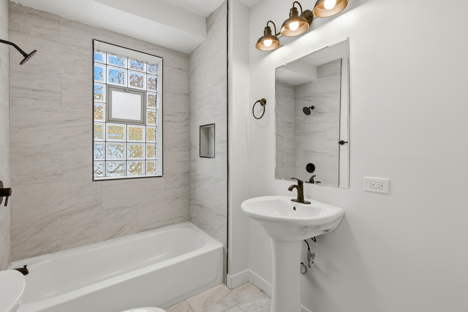 8942 South Aberdeen Street Chicago, IL 60620 - Photo 22 of 35 a bathroom with a sink a bathtub and a mirror