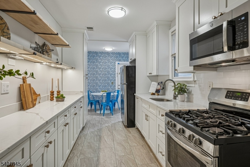 9 Wheeler Street Montclair, NJ 07042 - Photo 5 of 13 a kitchen with stainless steel appliances a sink a stove top oven a counter space and cabinets