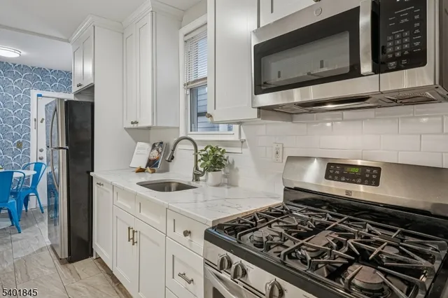 a kitchen with stainless steel appliances granite countertop a stove and a microwave