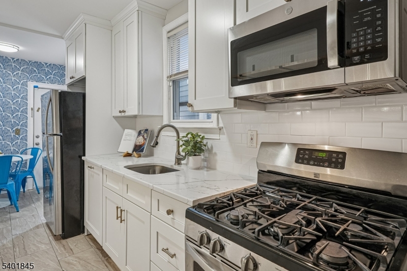 9 Wheeler Street Montclair, NJ 07042 - Photo 6 of 13 a kitchen with stainless steel appliances granite countertop a stove and a microwave
