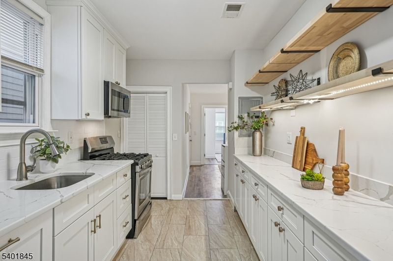 9 Wheeler Street Montclair, NJ 07042 - Photo 7 of 13 a kitchen with a sink dishwasher a stove and a refrigerator with wooden floor
