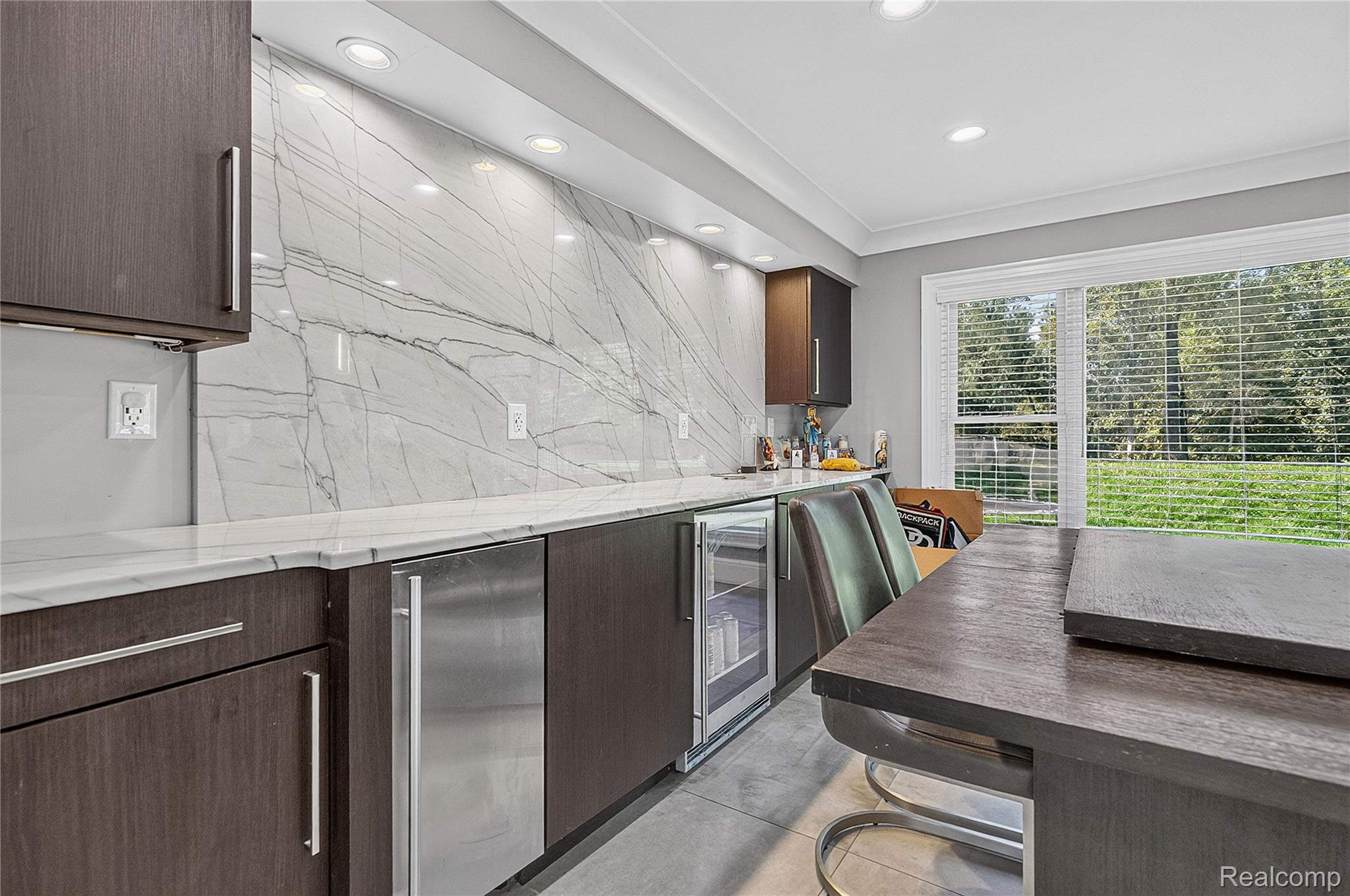 15879 Millar Road Clinton Township, MI 48036 - Photo 13 of 65 Contemporary wet bar featuring dark wood-finish cabinetry, white marble-look countertops, a built-in beverage cooler, and recessed lighting