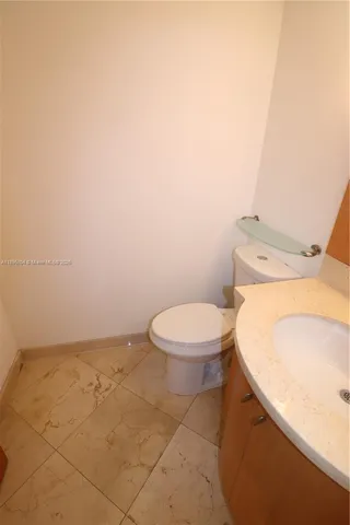 a white toilet sitting next to a white sink