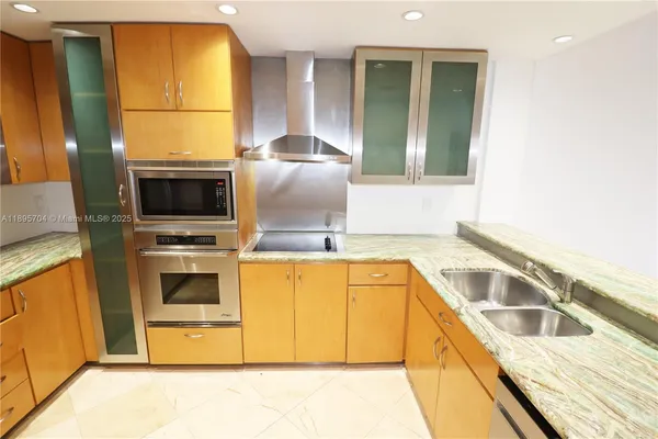 a kitchen with stainless steel appliances a stove a microwave and a sink