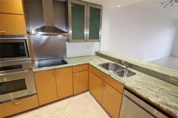 a kitchen with granite countertop a sink and stainless steel appliances