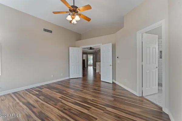 a view of an empty room with window and wooden floor