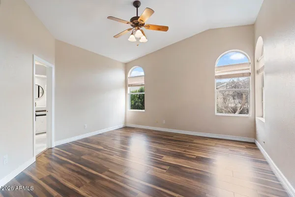 a view of an empty room with chandelier fan