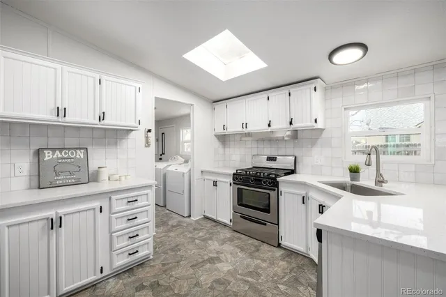 a kitchen with cabinets appliances a sink and a window