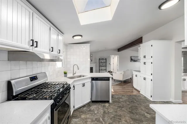 a kitchen with stainless steel appliances a stove a sink and a refrigerator