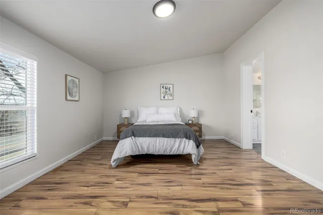 a bedroom with a bed and wooden floor