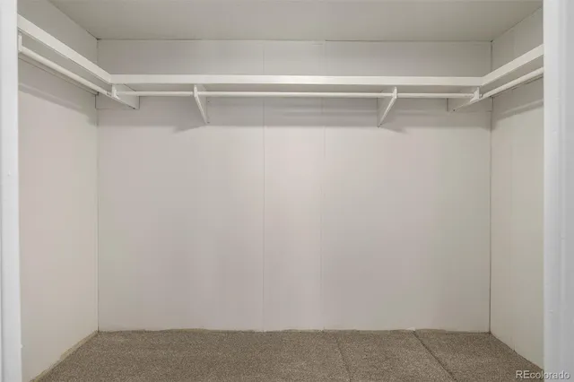 a view of walk in closet with clothes