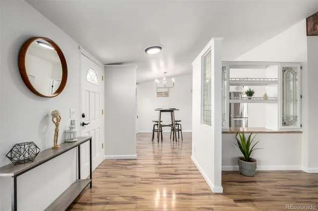 a view of a hallway with wooden floor windows and a kitchen