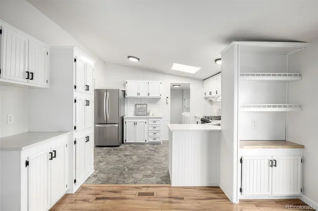 a kitchen with white cabinets and refrigerator
