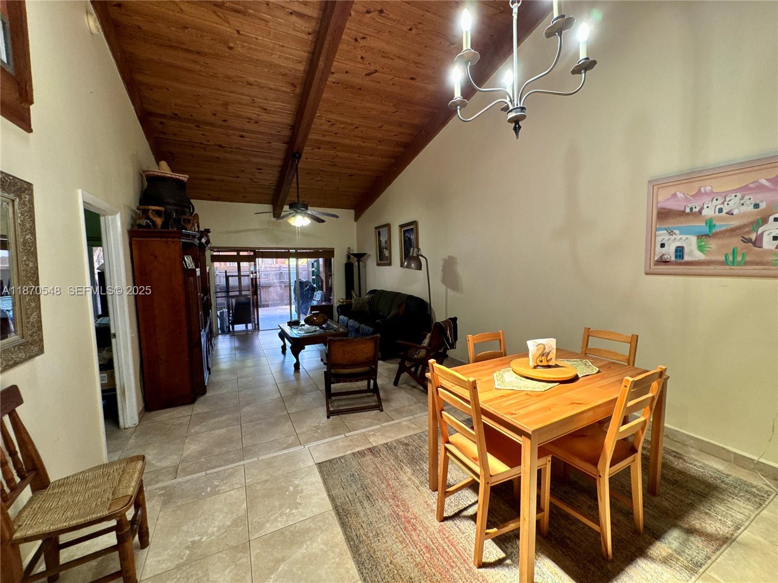 13527 Southwest 101st Lane Miami, FL 33186 - Photo 11 of 45 a dining room with furniture and a chandelier